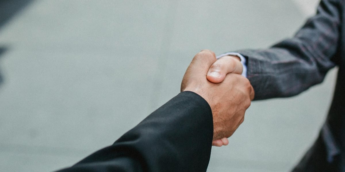 A professional handshake between a client and a real estate broker, symbolizing trusted relationships in off-market property acquisition.