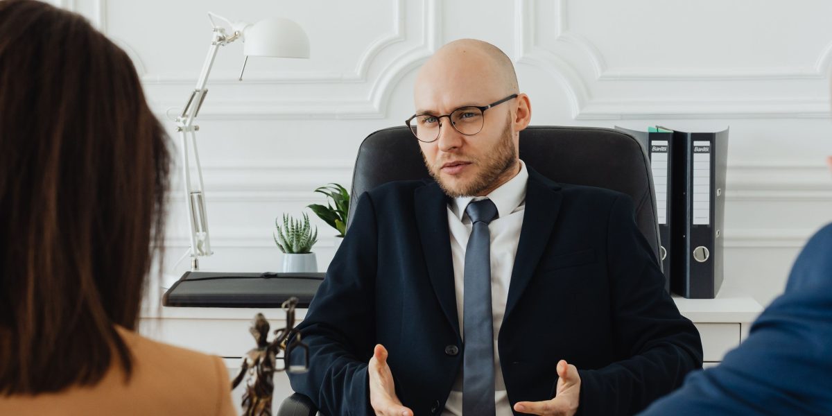 A lawyer explains complex legal documents to a client, emphasizing the importance of expert guidance for private acquisitions.