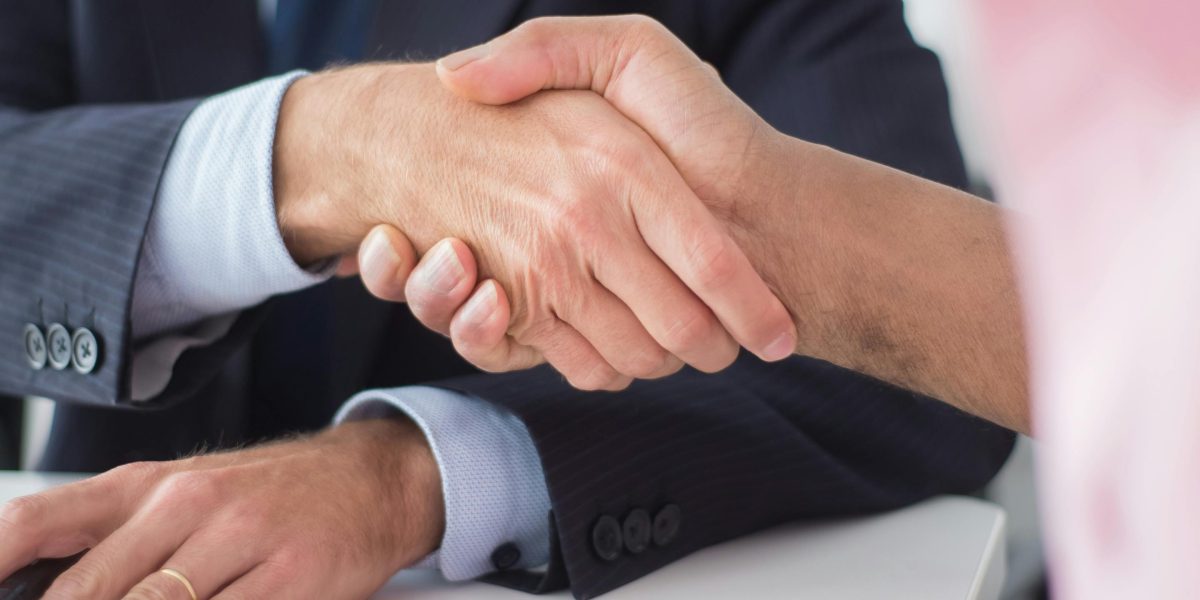 A professional client and real estate agent shaking hands, symbolizing a trusted partnership.