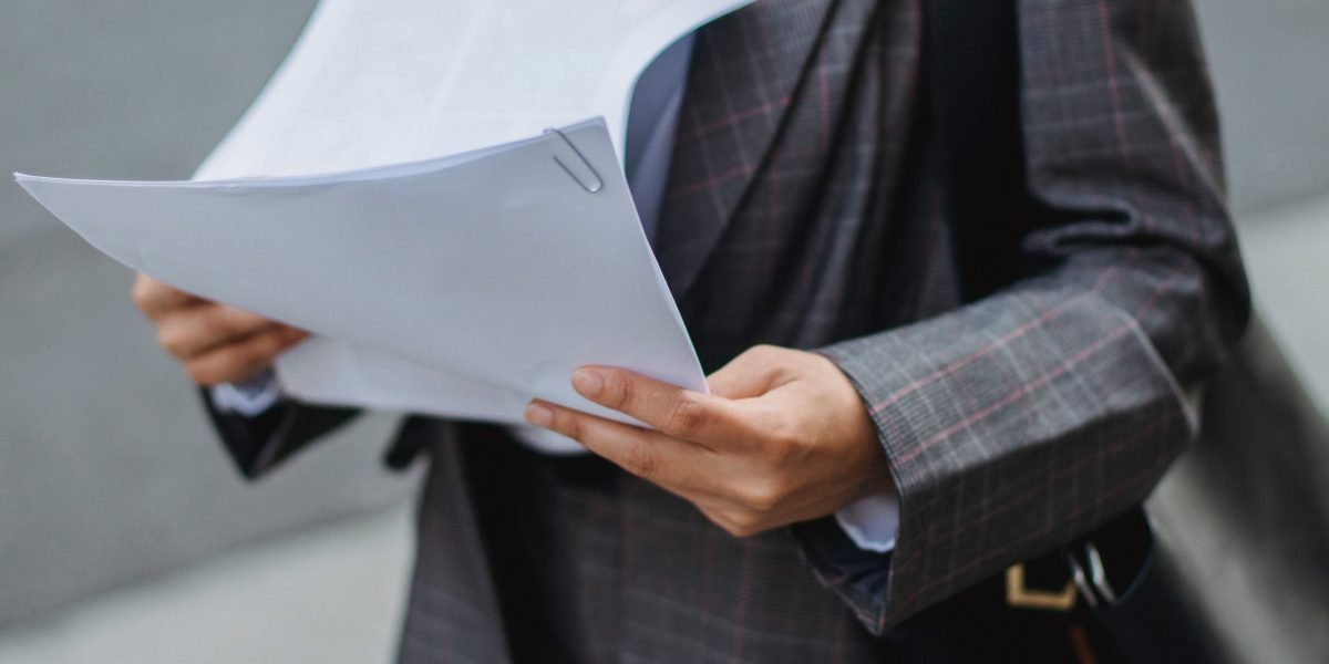 A professional meticulously reviews financial documents related to a high-value property investment.