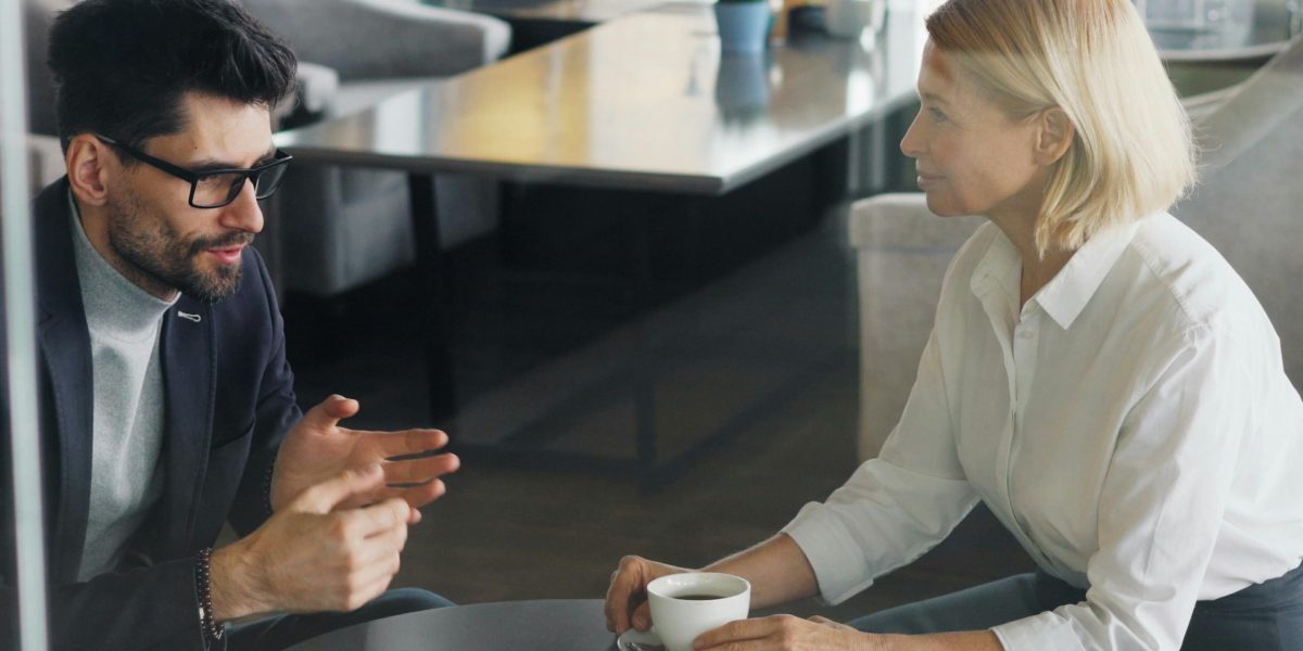 Professionals engage in a private discussion, hinting at exclusive opportunities.