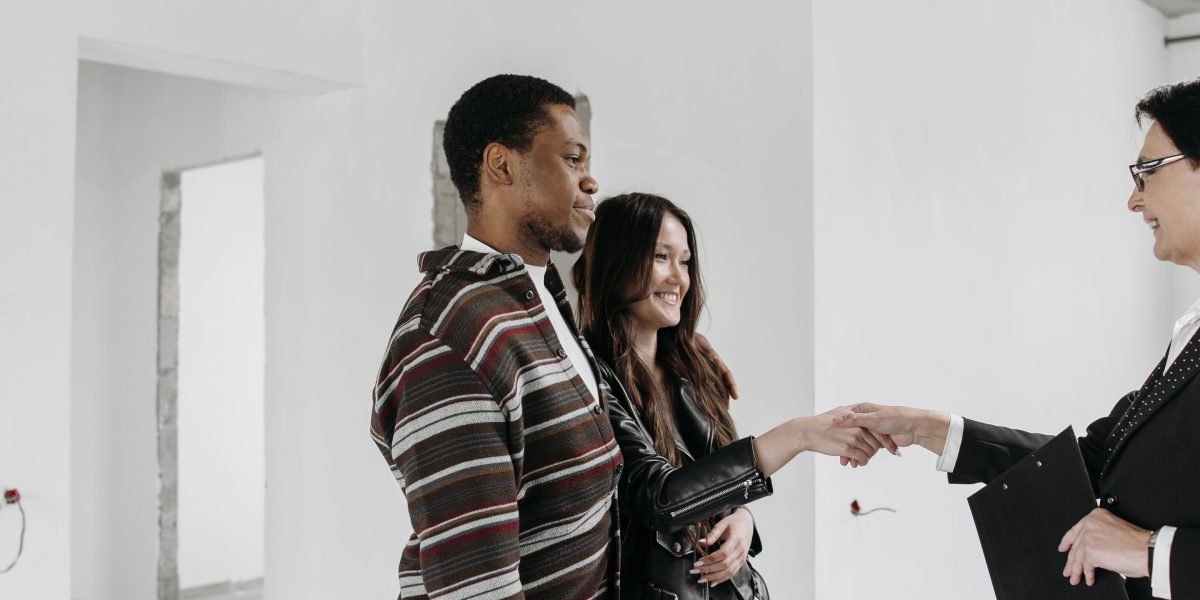 An experienced real estate agent meets with clients, discussing exclusive property opportunities.