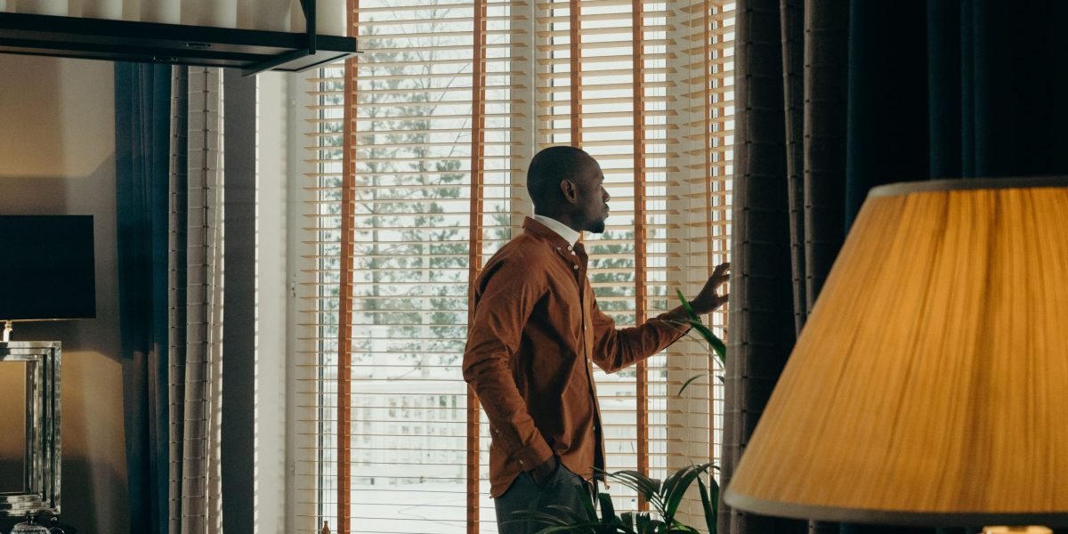 A person enjoying a serene view from a modern luxury home, embodying the lifestyle offered by Washington State's premium properties.