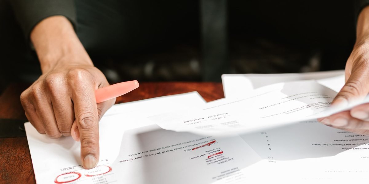 A confident individual thoughtfully reviewing financial documents, reflecting the strategic planning involved in financing luxury real estate.