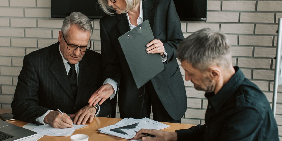 Professionals engaged in a discreet conversation, illustrating the importance of exclusive networks for accessing off-market luxury listings.
