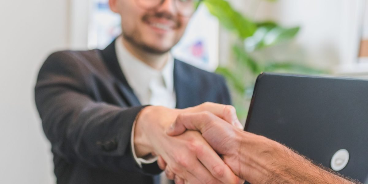 A professional and a client shaking hands, symbolizing trust and expert guidance.