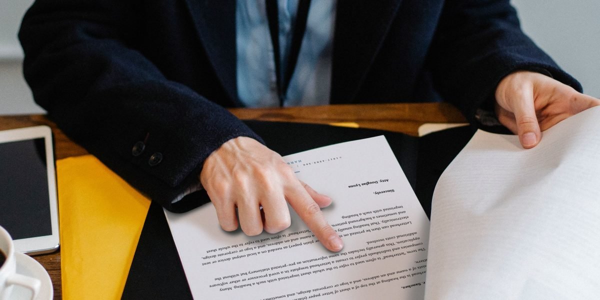 A person diligently reviewing documents at a table, focused on property analysis.