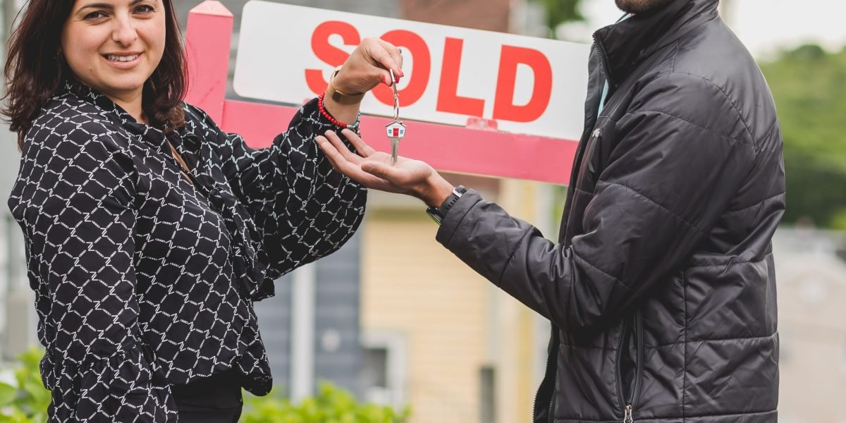 A happy couple celebrating a successful property purchase, holding keys to their new luxury home in Dubai.