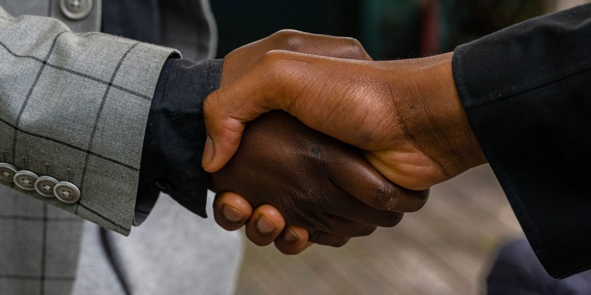 A successful meeting concludes with a handshake, symbolizing trust and a strong partnership in real estate investment.
