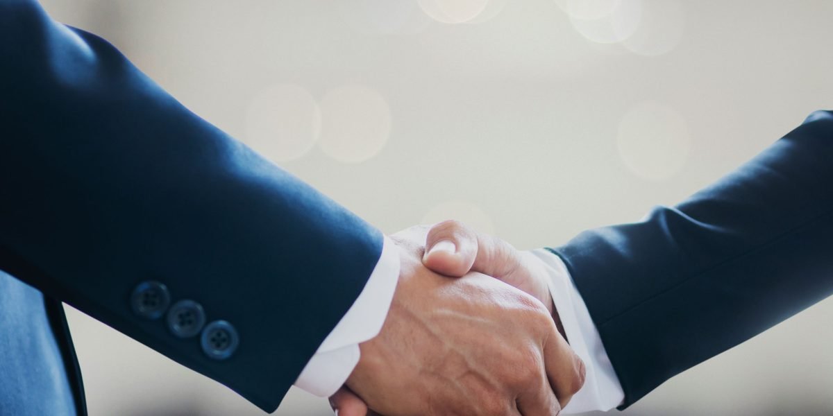 Two professionals shaking hands, symbolizing trust and a successful agreement after careful due diligence and valuation in luxury property.