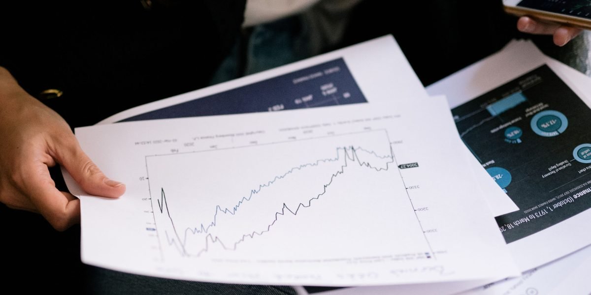 A global investor thoughtfully reviewing their investment portfolio, considering diversification into luxury real estate.