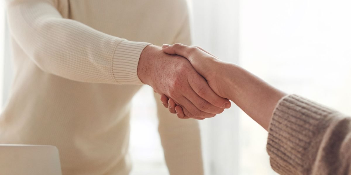 A handshake between business partners, symbolizing a successful and discreet high-value property transaction.